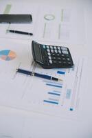 Financial analysts analyze business financial reports on a digital tablet planning investment project during a discussion at a meeting of corporate showing the results of their successful teamwork. photo