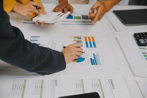 Financial analysts analyze business financial reports on a digital tablet planning investment project during a discussion at a meeting of corporate showing the results of their successful teamwork. photo