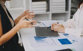 Financial analysts analyze business financial reports on a digital tablet planning investment project during a discussion at a meeting of corporate showing the results of their successful teamwork. photo
