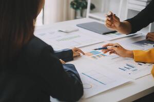 Financial analysts analyze business financial reports on a digital tablet planning investment project during a discussion at a meeting of corporate showing the results of their successful teamwork. photo