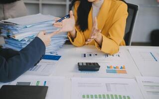 Financial analysts analyze business financial reports on a digital tablet planning investment project during a discussion at a meeting of corporate showing the results of their successful teamwork. photo