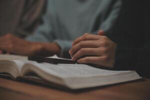 Christian group are praying to god with the bible and sharing the gospel. Concept of faith for god. photo