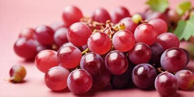 Top view of red grapes on pastel pink background. photo
