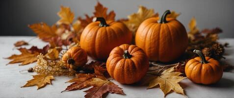 Pumpkins and fall leaves on white table background Thanksgiving day and Halloween concept Fall harvest and crop Flat lay autumn composition with copy space. photo