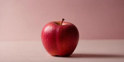 Single red apple in front of pink background. photo