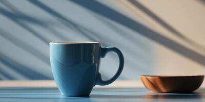 Cup of coffee casting shadows on blue surface. photo