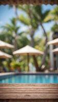empty wood table top and blurred swimming pool in tropical resort in summer banner background can used for display or montage your products. photo
