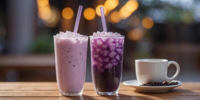 two tall glasses of layered purple and white bubble tea taro flavored placed on a wooden table. photo