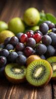 Fresh kiwis and grapes on wooden background. photo