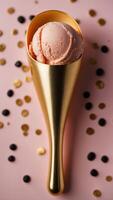 Golden ice cream scoop in black cone on pink background. photo