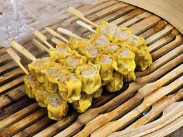 Steamed dumplings with pork and shrimp on skewers, steamed on a bamboo steamer photo