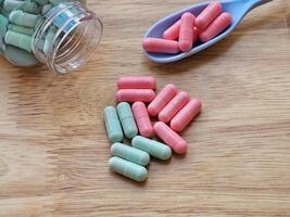 Pill box, vitamins on a spoon and vitamins on a wooden board represent a health care concept and food supplement. photo