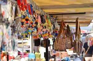 Colorful Souvenir Stall in Coastal Bazaar A lively image of a market stall filled with colorful keychains, bags, and other souvenirs in a coastal bazaar. This photo captures the essence of a bustling