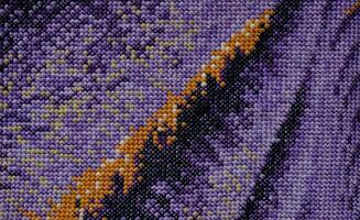 Purple, violet and brown close-up cross stitch background. Abstract Embroidered handmade Pattern. Needlework and DIY concept. Top view, macro, flat lay, mockup. photo