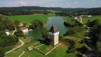 Aerial orbiting view of tower house Ticha and pond in Czechia in August 2024 video
