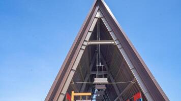 Metal Structure Against the Sky. A low angle view of a large metal triangular structure against a bright blue sky. photo