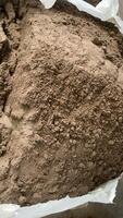 Bottom ash from the waste recycling factory in a Bag. Close-up image of a bag filled with brown sand, showing its granular texture and earthy tones. photo