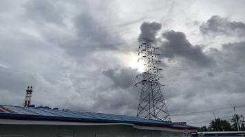 Electricity Tower Against a Cloudy Sky. A tall electricity tower stands against a cloudy sky, its power lines stretching across the frame. photo