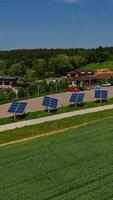 moderno complexo com fotovoltaico células. linha do solar painéis ao longo a estrada dentro natureza panorama. sustentável energia. aéreo visualizar. vertical video