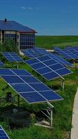 Solar panels on field. Modern architecture among nature with sunny batteries on roof and outer wall. Renewable source of clean energy. Vertical video