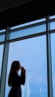 woman in eyeglasses while standing by the window Vertical video