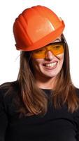 Pretty woman engineer in an orange helmet tells a story about something and holds a folder-tablet with pen in her hands on a white background. Vertical video