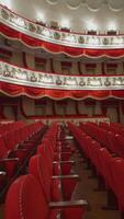 Beautiful vacant theater. Large hall with comfortable red armchairs without audience or crowd. Empty seats in a modern opera house. Closed place or venue. Vertical video