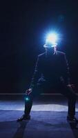 Senior man in costume on stage in darkness. Active man in hat dancing on stage during the performance in the theater. Vertical video
