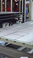 Producing process of solar panel. Automated technology of producing solar cells. Ready solar panel on the board on a modern factory background. Vertical video