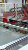 Solar panel is moving on a conveyor belt. Automated machine for producing solar cells inside the modern factory. Vertical video