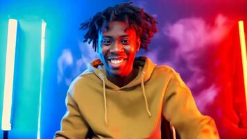 A man with dreadlocks standing in front of a colorful background video
