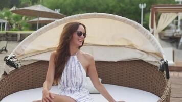 Mädchen freut sich auf ein Strand Sofa. Freude und Vergnügen auf ihr Gesicht. Kamera Bewegung video