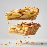 a piece of pie with apples falling out of it photo