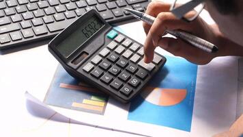 A person is using a calculator to calculate the value of a business video