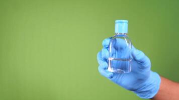 Hand in blue glove holding a small bottle of water video