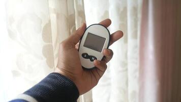 A person holding a remote control in front of a window video