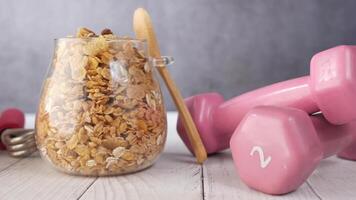 Granola in a glass jar with a spoon and dumbbells video