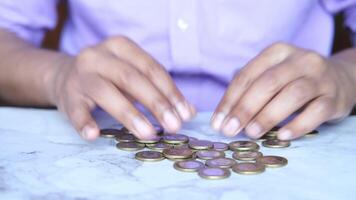 A person is counting coins on a table video