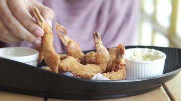 A person is holding a piece of fried shrimp video