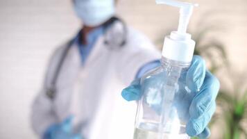 A doctor holding a bottle of hand sanitizer video