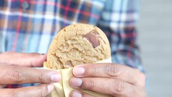 A person holding a cookie with a chocolate chip cookie video