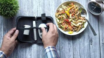 A person is holding a fork and spoon in front of a bowl of food video