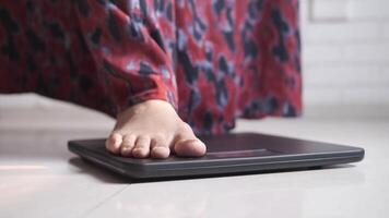 A person standing on a scale with their feet on it video