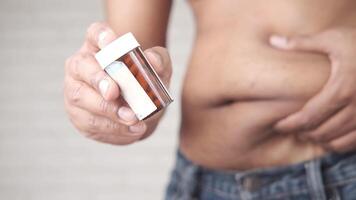 A man holding a pill bottle with a man's stomach video