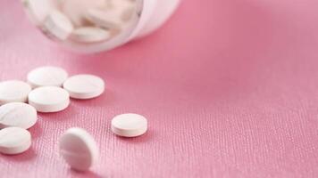 White pills on a pink background video