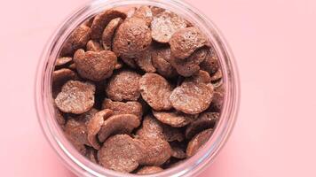 A glass jar filled with chocolate chips on a pink background video