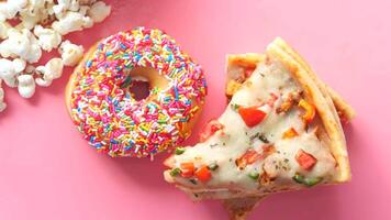 A slice of pizza and a donut on a pink background video