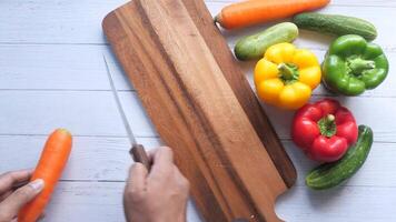 A person cutting vegetables with a knife on a cutting board video