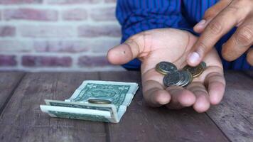 A man is holding a stack of coins and a stack of money video