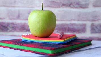 Apple on a desk with a notebook and pencil video